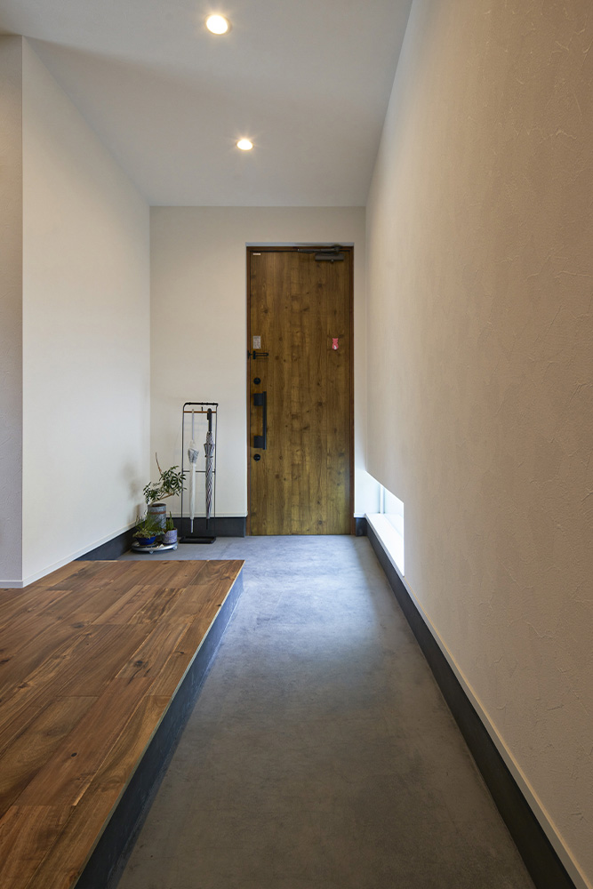 L字型で広さにゆとりのある玄関土間。ダウンライトやアカシアの床が上質な趣を添える