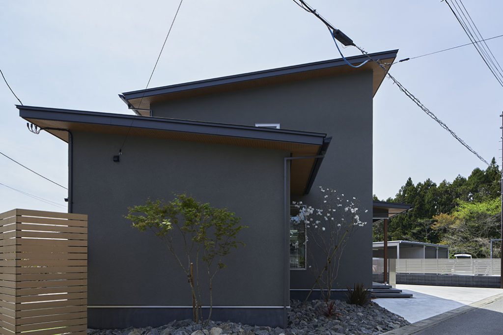 高台に建つSさん宅。ダークな塗り壁が重厚感を引き立たせる。屋根には約6kWの太陽光発電パネルを搭載