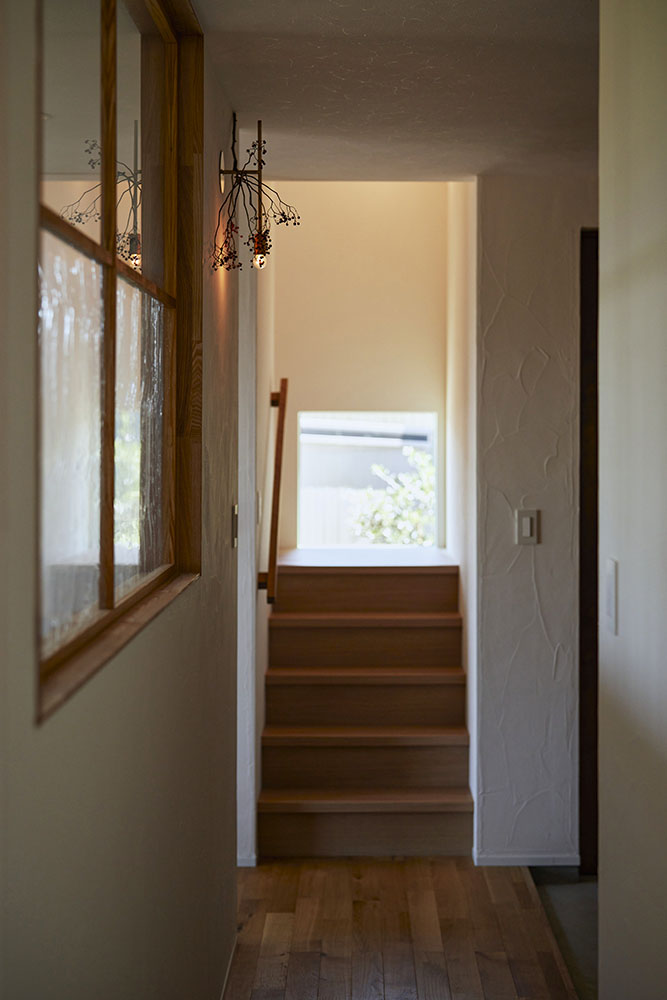 階段の踊り場に設けられた四角い窓からは庭のオリーブの木を眺めることができる