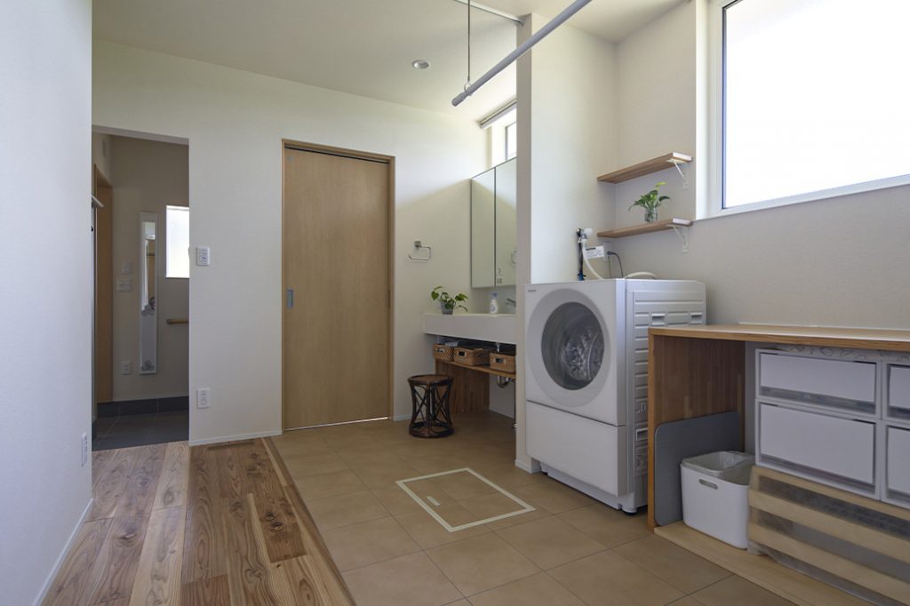 大きな窓を設けたため北側でも明るく、洗濯の作業もしやすい。正面はトイレのドアで、玄関がすぐ隣にある