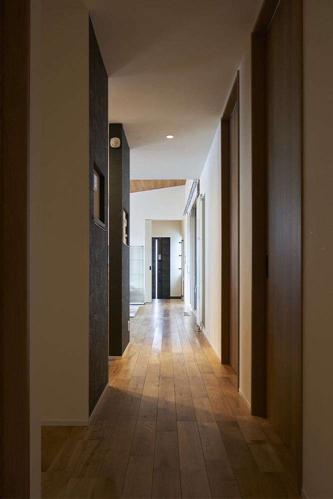 極力コンパクトに設計した1階の廊下は、右手の洗面脱衣室、左手のキッチンやトイレ、書斎スペースをつなぐ役割を果たしている