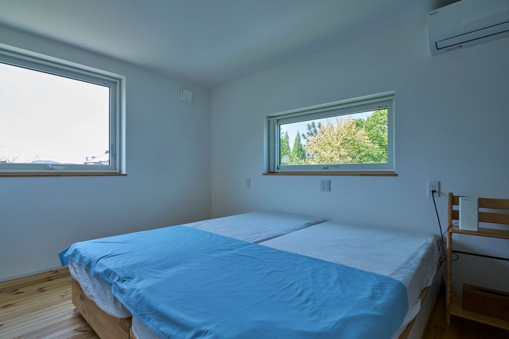 窓から庭の豊かな緑を一望できる寝室。広さは6帖で、部屋の一角にはウォークインクローゼットも備えた