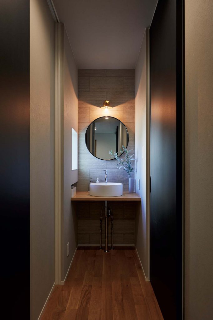 1階のトイレ横の手洗いスペース。落ち着いた雰囲気の空間に、木づくりの造作家具が溶け込む