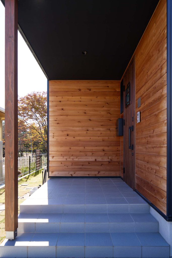 玄関まわりは木張りで仕上げ、異素材によるアクセントと温もり感をプラス